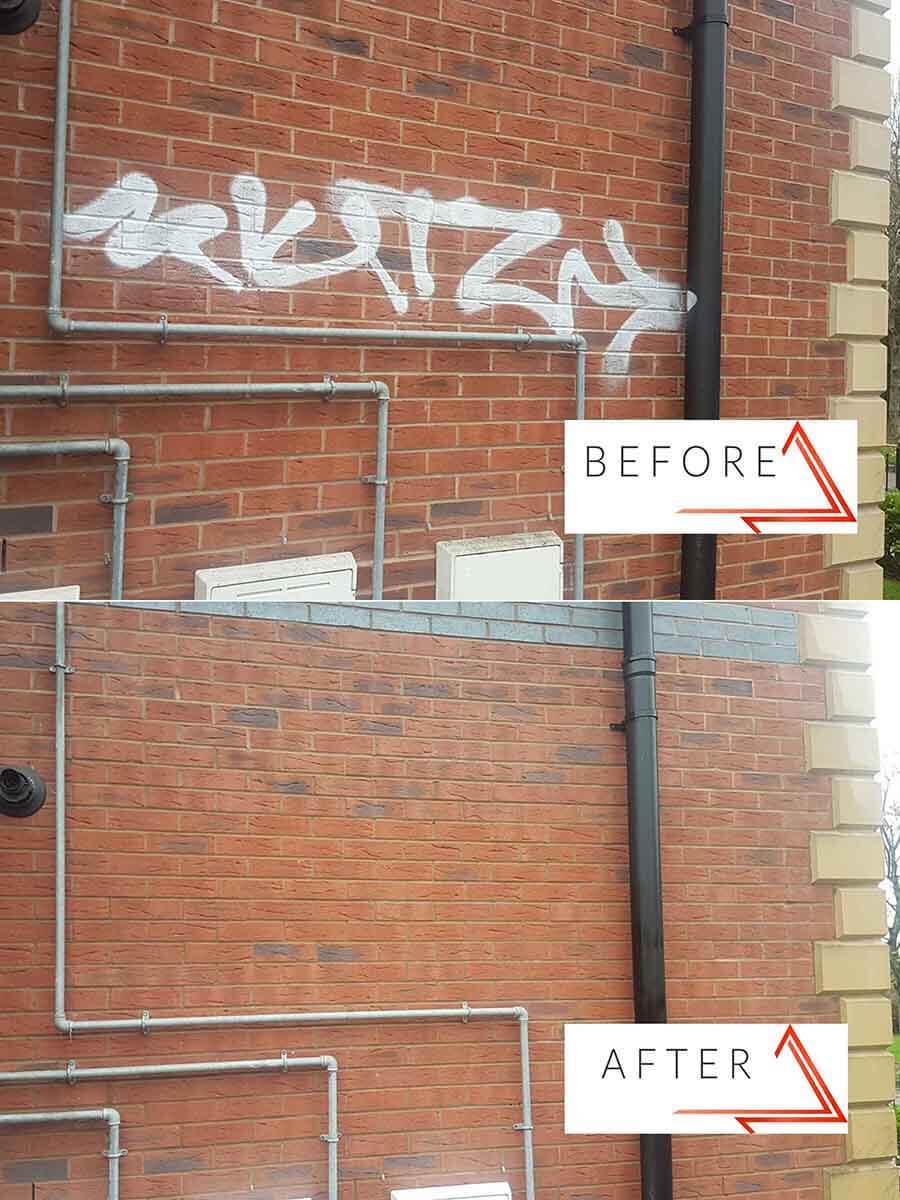 Graffiti removal from brick wall with pipes